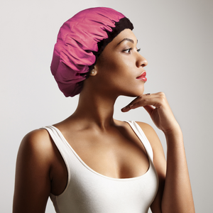 Woman wearing pink Lava Cap microwavable heat cap for hair treatments