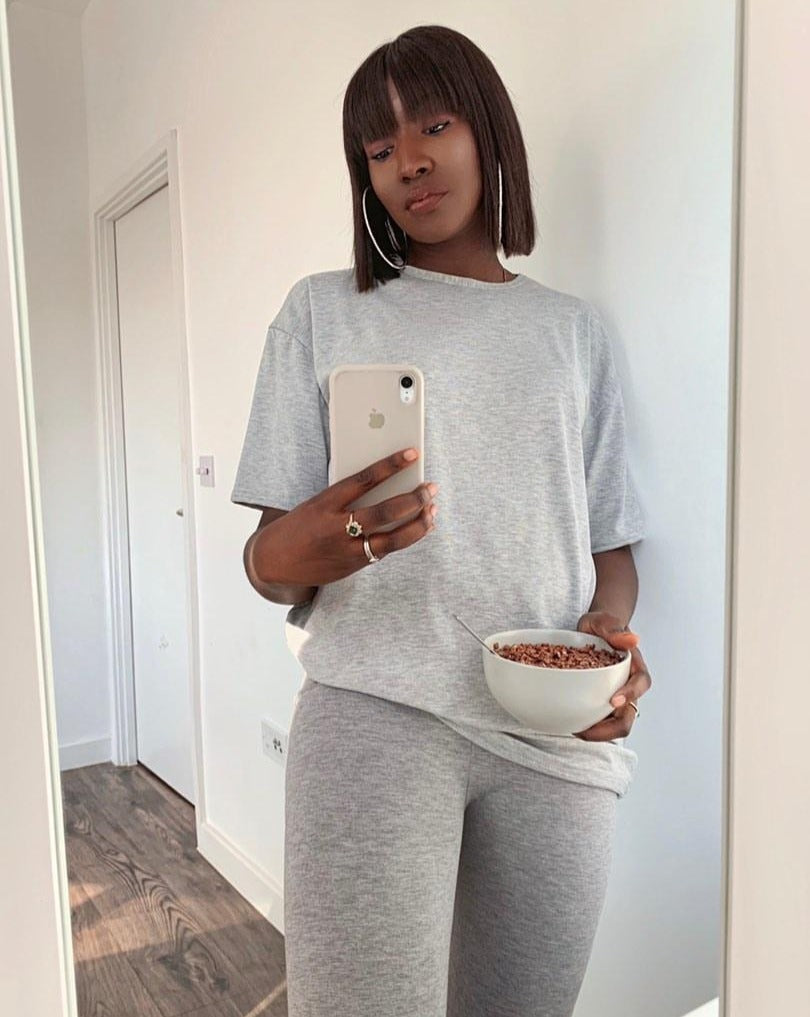 beautiful woman wearing grey causuals taking selfie wearing bob wig with fringe 