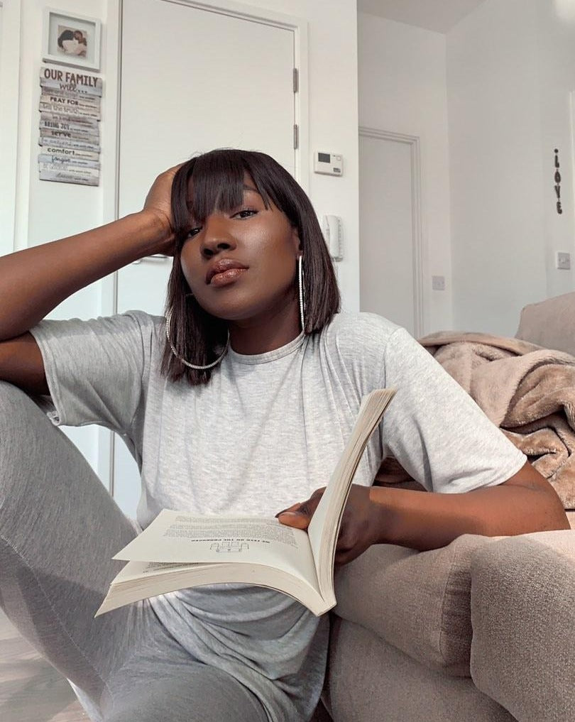beautiful woman holding book wearing bob wig with fringe 