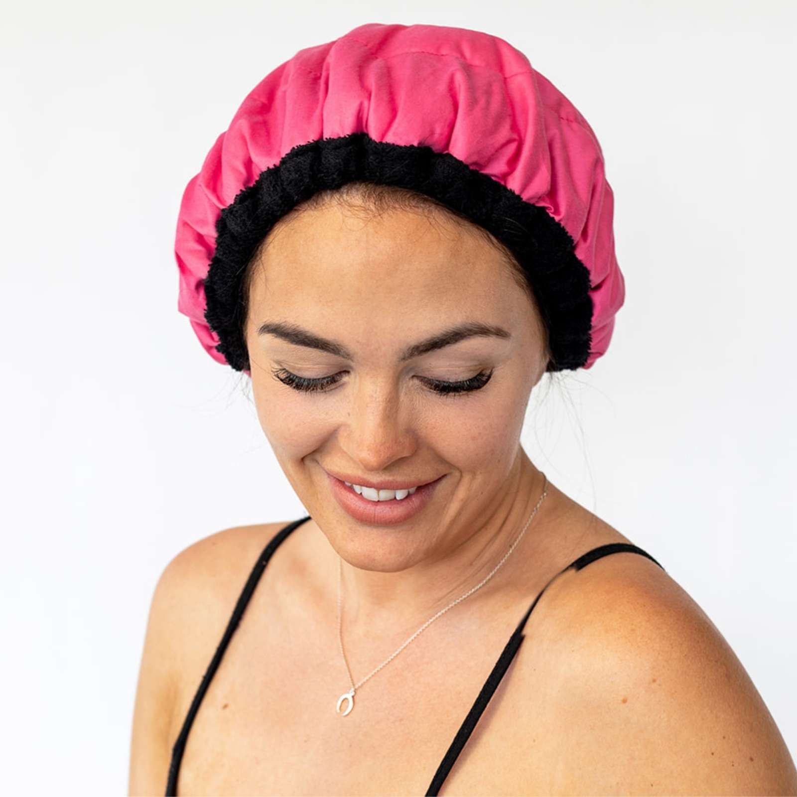 Woman wearing pink Lava Cap microwavable heat cap for hair treatments