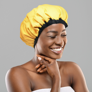 Woman wearing yellow microwavable flaxseed-filled deep conditioning heat cap while smiling